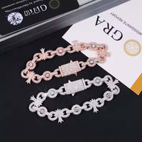 A Silver Moissanite Cross Infinity Bracelet with sparkling, diamond-like stones and unique links is displayed on a black surface beside a certificate and jewelry box.