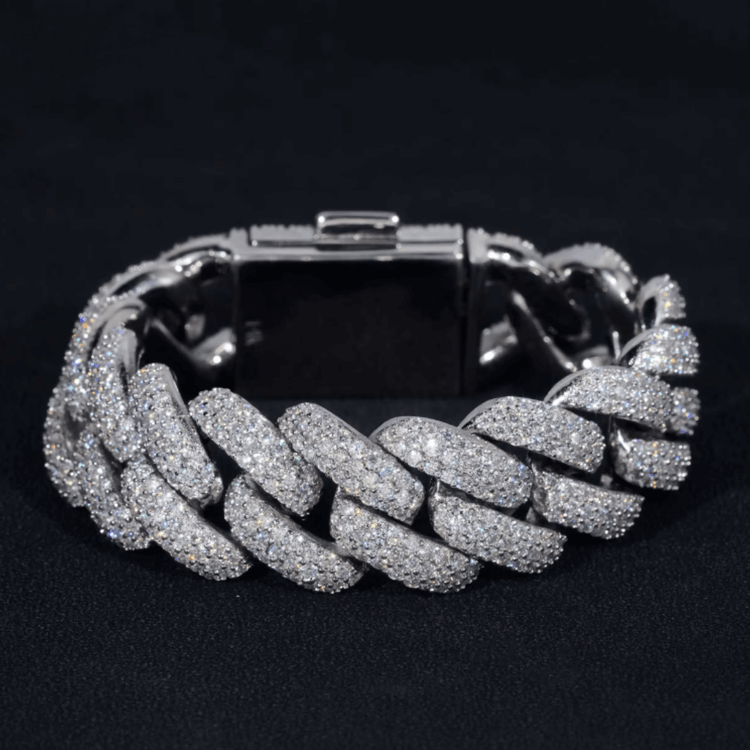 The Silver Moissanite Cuban Link Bracelet – 20mm features a chunky design with shimmering stones set in polished 925 silver, shown against a black background.