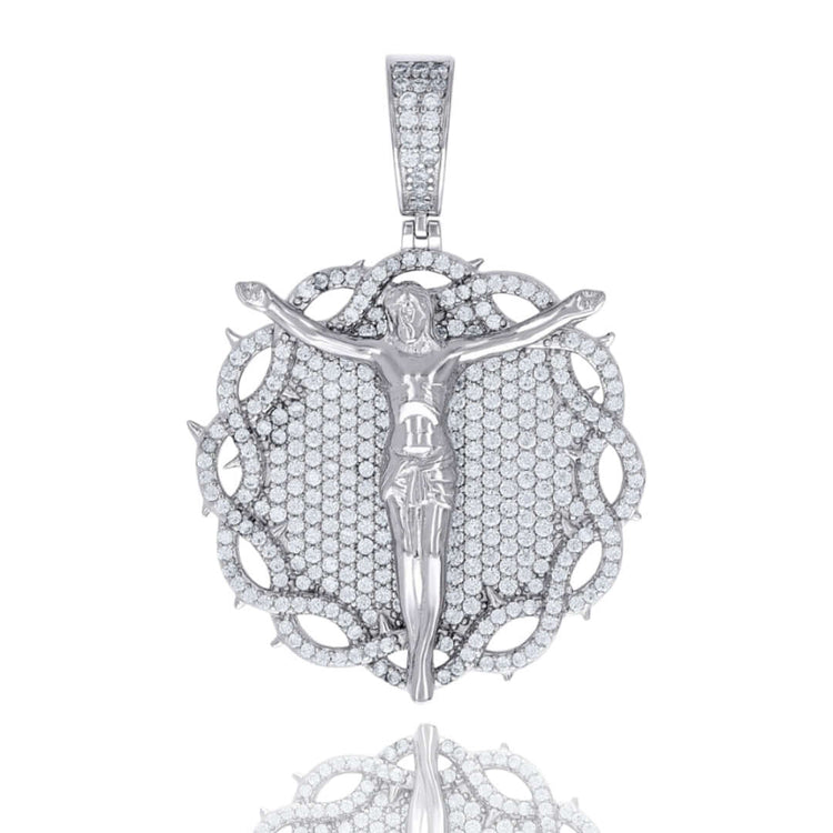 The Silver Round Moissanite Crucifix Charm Pendant features a sterling silver design with a Jesus figure, VVS moissanite-studded round background, thorn-like border, and a sparkling stone-encrusted bail.
