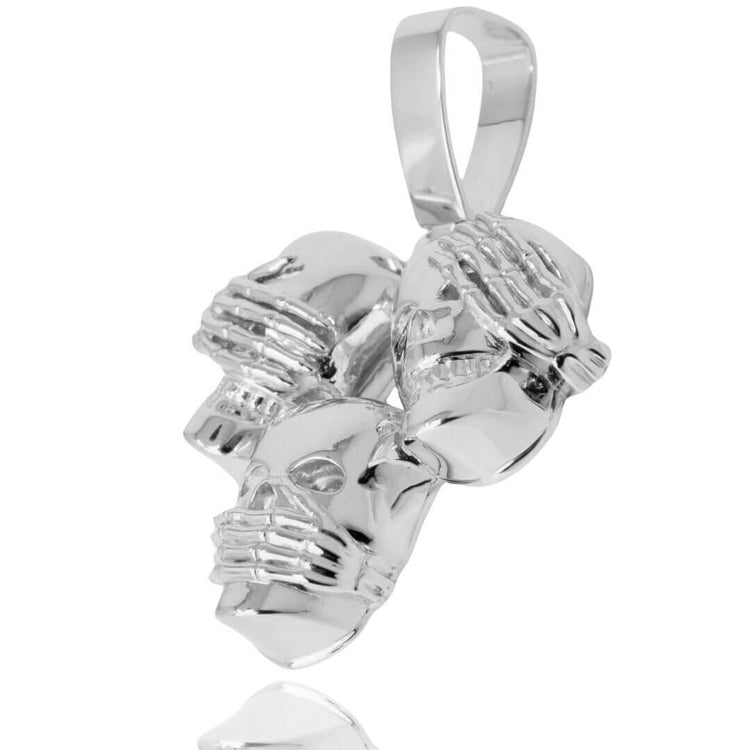 The Hear No Evil, See No Evil, Speak No Evil Silver Pendant features three skulls with hands over their eyes, ears, and mouth, reflecting the three wise monkeys' motif. This mindful jewelry piece boasts a shiny, reflective silver finish.