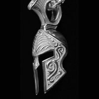 A close-up of the Silver Spartan Helmet Pendant showcases its detailed swirling engravings and bold crest against a black background—an exquisite piece of jewelry for anyone inspired by the warrior spirit.