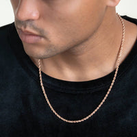 A person wearing a black shirt and the Rope Chain - 2mm-5mm Solid Rose Gold necklace, shown from the shoulders up with their face partially visible.