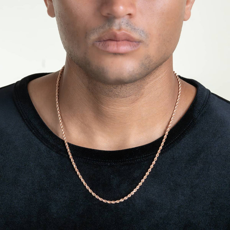 A person wearing a black shirt and the Rope Chain - 2mm-5mm Solid Rose Gold necklace, shown from the shoulders up with a neutral facial expression against a light background.