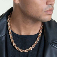 A man in a black shirt and leather jacket showcases the Rope Chain - 6mm-12mm Solid Rose Gold necklace. The cropped image focuses on his lower face and neck, drawing attention to the eye-catching rose gold accessory.