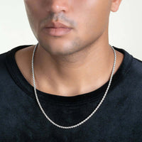 A person wearing a Rope Chain - 2mm-5mm Solid White Gold necklace and a black shirt, shown from the shoulders up against a plain light background.