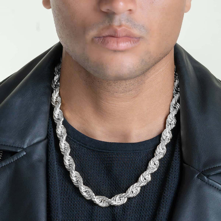 A person wears a black textured shirt, a black leather jacket, and the Rope Chain - 6mm-12mm Solid White Gold. The shot highlights their lower face, neck, and chest, keeping the eyes out of frame.