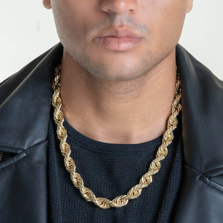 A person wears a black shirt, black leather jacket, and the Rope Chain - 6mm-15mm Solid Yellow Gold necklace. The image captures the lower face and upper chest with no background—this bold chain is truly a statement piece.
