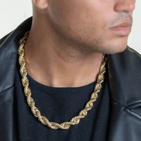 A person wears the Rope Chain - 6mm-15mm Solid Yellow Gold necklace with a black mesh shirt and leather jacket, photographed from the shoulders up with their face partly out of frame.