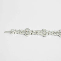 The Moissanite Cross Fancy Bracelet, crafted from 925 sterling silver and adorned with round, sparkling gemstones in floral-inspired patterns, is displayed against a plain white background.