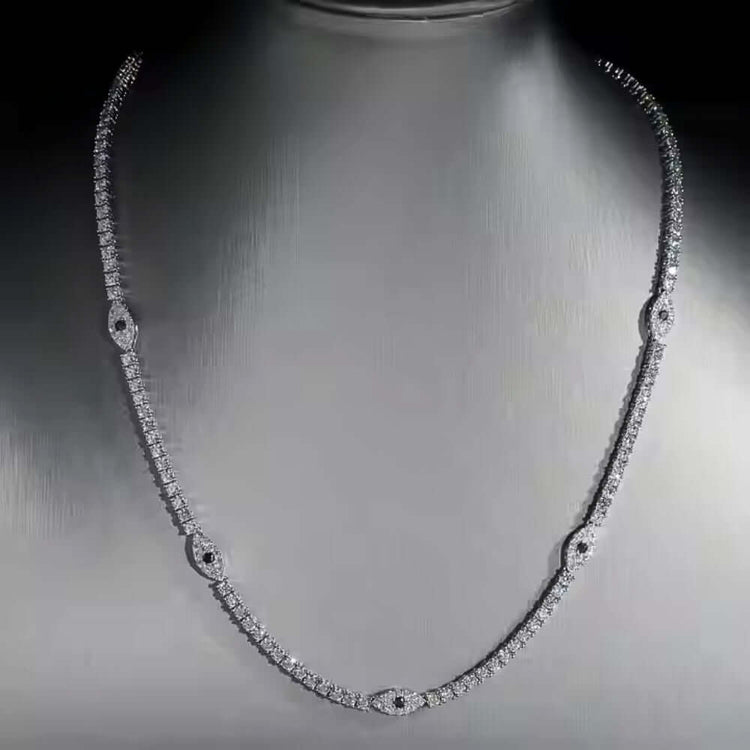 The Evil Eye Tennis Chain - 3mm, featuring an alternating pattern of round and marquise-shaped diamond clusters, is displayed on a gray bust.