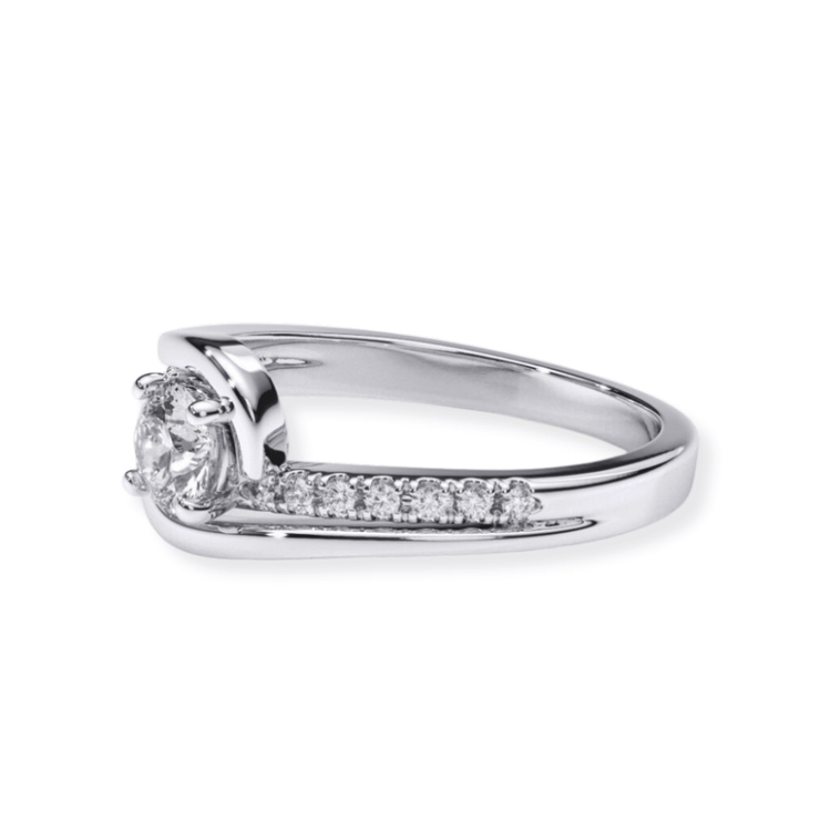 The Swirl Pavé Round-Cut Lab Diamond Engagement Ring features a round lab diamond in a modern bypass design with pavé accents along one side of the white gold band.