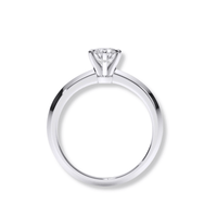 The Timeless Six-Prong Solitaire Lab Diamond Ring features a round lab diamond in a polished white band, viewed from the side against a white background—a classic women’s engagement ring.