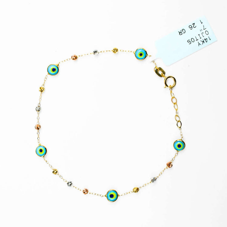 The 5 Lucky Eye Bracelet - 14k features delicate gold with blue and yellow charms and metallic beads, arranged in a circle with a clasp and white tag, blending elegance with spiritual protection.