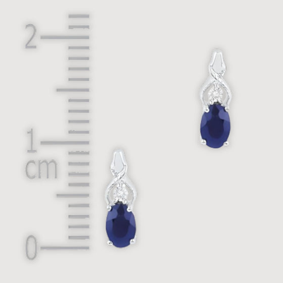 alt=" Discover versatile 10K gold earrings with synthetic blue sapphire that shine in any setting, perfect for elevating both casual and formal outfits. "