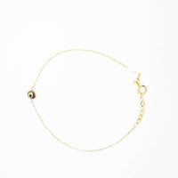 The one lucky eye bracelet - 14k is a delicate gold bracelet featuring a small, round evil eye charm for spiritual protection and a secure lobster clasp, shown on a white background.