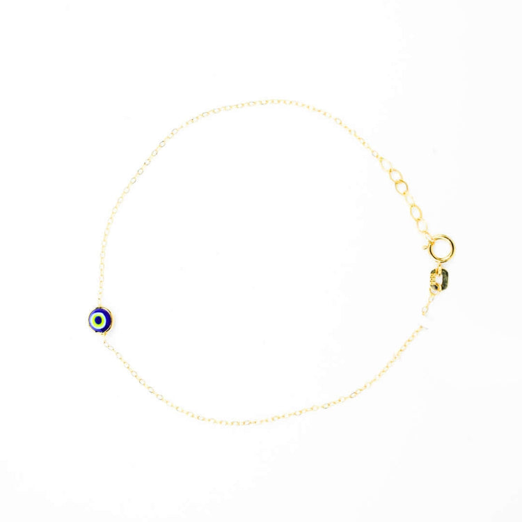 The one lucky eye bracelet - 14k is a delicate gold bracelet featuring a small blue evil eye charm for spiritual protection, secured with a lobster clasp and shown on a white background.