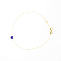 The one lucky eye bracelet - 14k is a delicate gold bracelet featuring a small blue evil eye charm for spiritual protection, secured with a lobster clasp and shown on a white background.