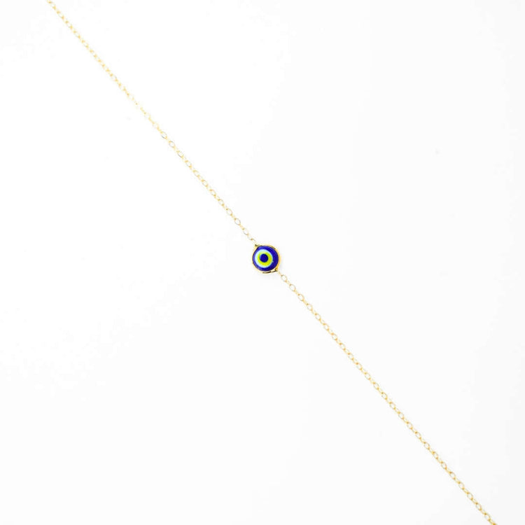 The one lucky eye bracelet - 14k features a delicate gold chain with a small, round blue, white, and yellow evil eye charm centered on a plain white background—combining stylish elegance with spiritual protection.
