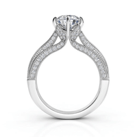 The Vintage Milgrain Solitaire Lab Engagement Ring with Pavé Diamond Band features a large round lab diamond in white gold, four-prong setting, split shank pavé band, and intricate vintage milgrain details for timeless elegance.