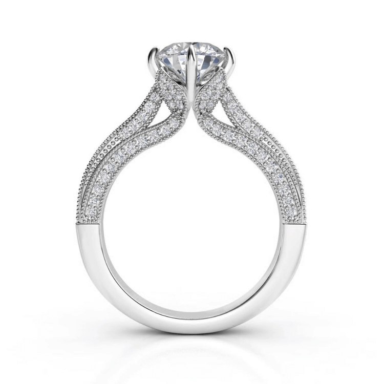 The Vintage Milgrain Solitaire Lab Engagement Ring with Pavé Diamond Band features a large round lab diamond in white gold, four-prong setting, split shank pavé band, and intricate vintage milgrain details for timeless elegance.