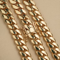 Close-up of three 6mm Handmade Miami Cuban Link Chains in 10K solid gold with box clasps, shown on a beige textured surface. Ready to ship.