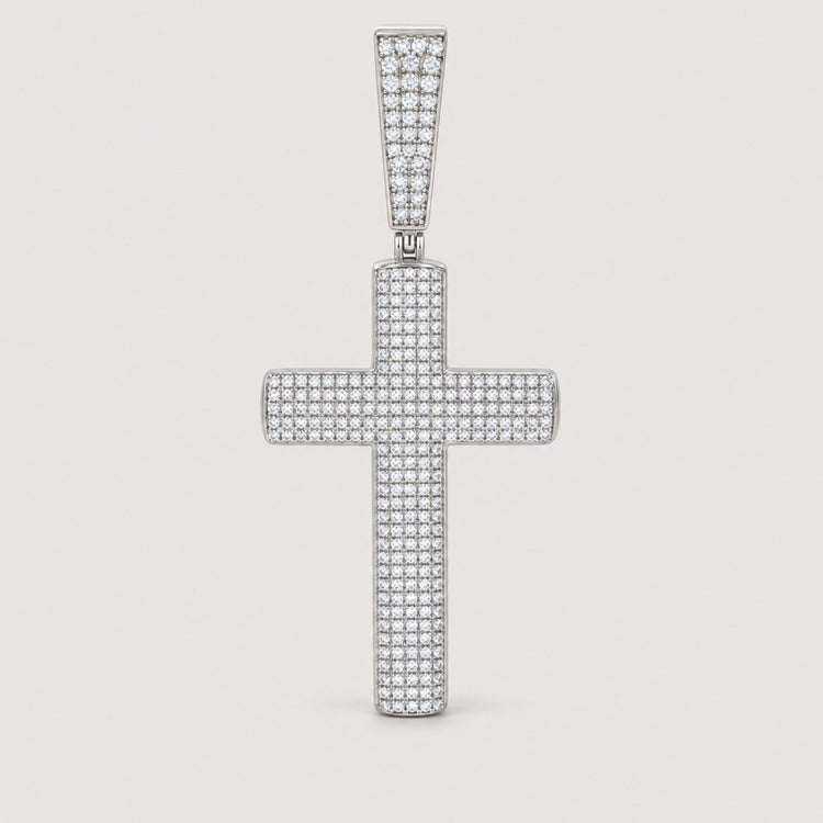 A Moissanite Cross Religious Charm Pendant adorned with small, sparkling stones is displayed against a plain, light background, capturing the timeless elegance of GOLDZENN jewelry in this sterling silver piece.