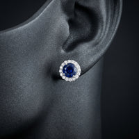 1-1/5CTW Round Blue Sapphire Diamond Halo Stud Earrings – 14K White Gold displayed on ear - GOLDZENN