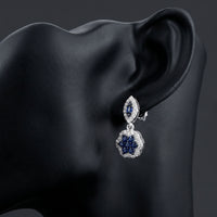 1/3CTW Diamond Flower Dangling Earrings 10k White Gold displayed on ear - GOLDZENN