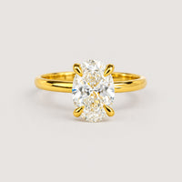 The 1.72ct oval-cut lab diamond engagement ring, set in 14k solid yellow gold, features a solitaire stone held by four prongs and is displayed on a warm off-white studio background.