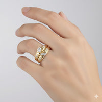 A hand with manicured nails wears the 10k Gold Diamond Matching Wedding Ring Set, featuring a round diamond ring and two detailed bands, shown against a simple light background.