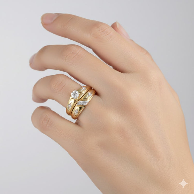 A hand with manicured nails wears the 10k Gold Diamond Matching Wedding Ring Set, featuring a round diamond ring and two detailed bands, shown against a simple light background.