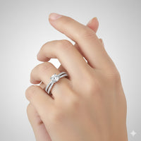 A close-up of a hand with manicured nails wearing the Double-Band Lab Diamond Engagement Ring with Brilliant Round Center on the ring finger, against a plain light background.