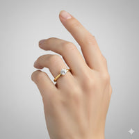 A hand with manicured nails wears a 0.73ct Round Lab Diamond Solitaire Engagement Ring in 14k Gold on the ring finger, set against a plain light gray background.