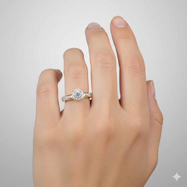 A hand with neatly manicured nails wears the 1/3CTW Diamond Round Single Halo Engagement Ring in 10k gold, featuring a round center stone surrounded by diamonds, paired with a matching band against a light gray background.