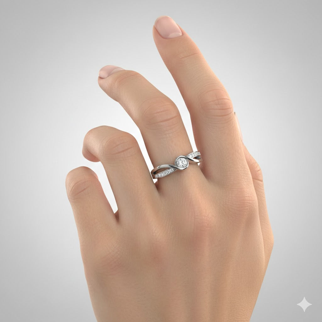A hand with manicured nails showcases the Engagement Twist Ring - Lab Diamond, a silver ring featuring a round lab-grown diamond and side stones in a delicate twisted design, set against a plain gray background.