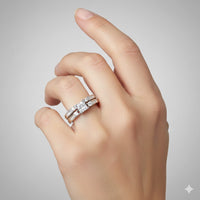 A light-skinned hand displays the 10k White Gold Princess Diamond Bridal Ring Set 3/8 Cttw on the ring finger, featuring a princess diamond wedding ring with side stones and a matching band against a plain light background.