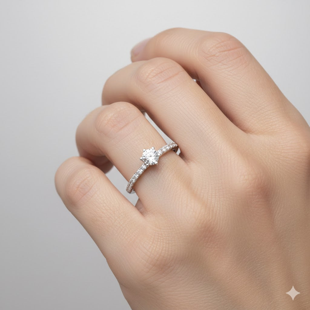 A hand displays the Classic Solitaire Lab Diamond Ring with Dazzling Pavé Accents and a matching diamond wedding band against a light gray background.