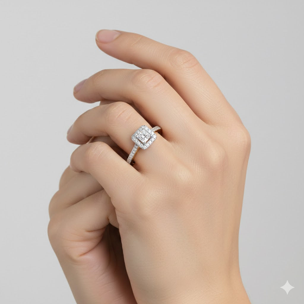 A close-up of a hand wearing the 10k Gold Princess Diamond Halo Engagement Ring, featuring a square-shaped center stone and diamond-studded band, set against a plain light background.