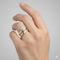 A light-skinned hand wearing two gold rings—one with a round diamond, the other with a striped gold and silver design—pairs perfectly with the 1/4CTW Diamond Heart Necklace Set in 10k Gold, shown against a plain light gray background.