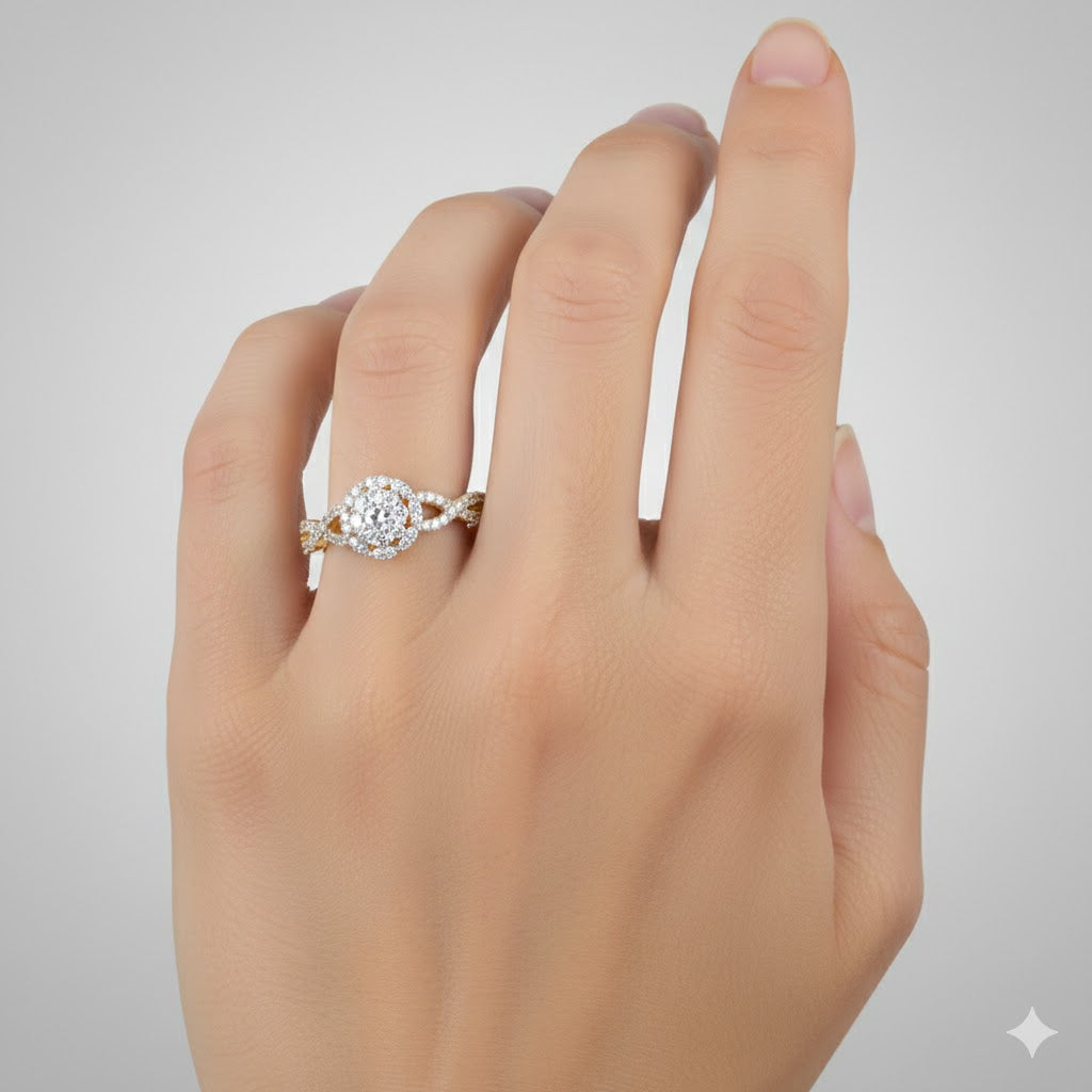 A hand with light skin tone wears the 1/2 CTW Diamond Flower Bridal Ring in 14K gold, showcasing a round center diamond surrounded by smaller diamonds on the ring finger, set against a plain light gray background.
