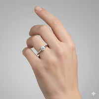 A light-skinned hand is shown against a plain gray background, wearing the Timeless Six-Prong Solitaire Lab Diamond Ring—a silver band featuring a single round lab diamond on the ring finger.