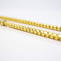 A close-up of two 3.5mm Franco Chains crafted in 10k solid yellow gold, featuring a sleek interwoven design and displayed against a clean white background.