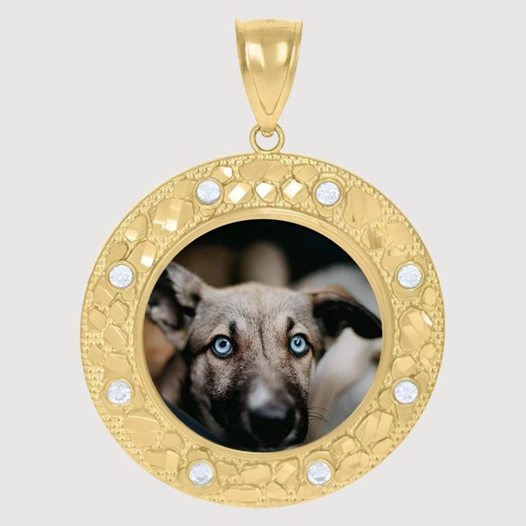 The 10k Solid Gold Picture Pendant Custom Medallion Frame has a textured border, embedded gems, and displays a photo of a blue-eyed, brown-furred dog in the center for a stunning personalized accessory.