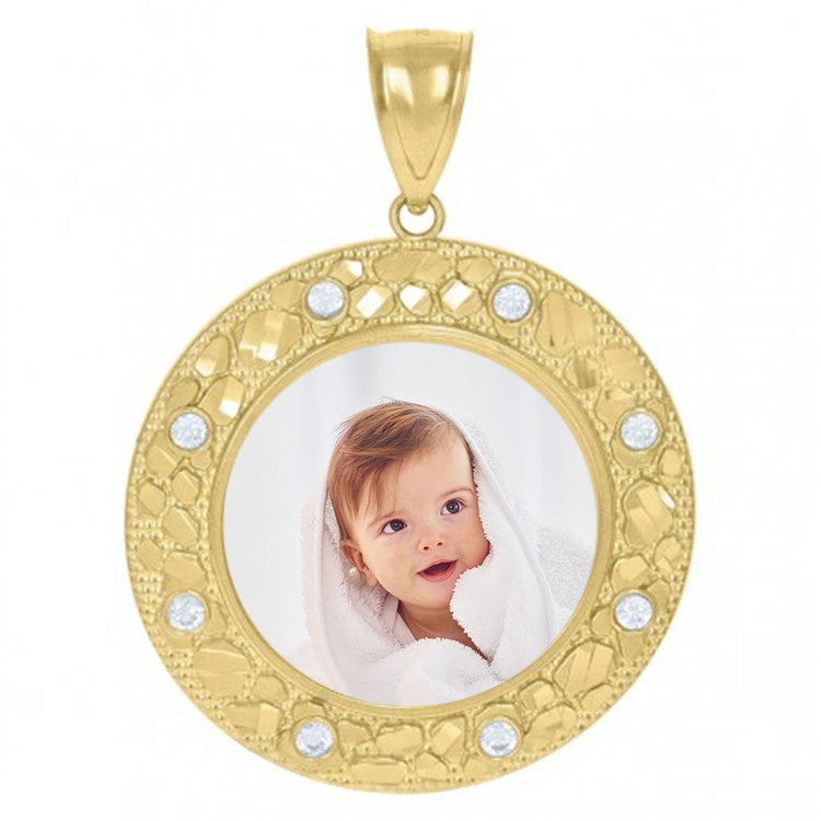 The 10k Solid Gold Picture Pendant Custom Medallion Frame is a round medallion with decorative patterns and small gems, showcasing a custom photo of a smiling baby wrapped in a white towel at its center.