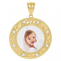The 10k Solid Gold Picture Pendant Custom Medallion Frame is a round medallion with decorative patterns and small gems, showcasing a custom photo of a smiling baby wrapped in a white towel at its center.