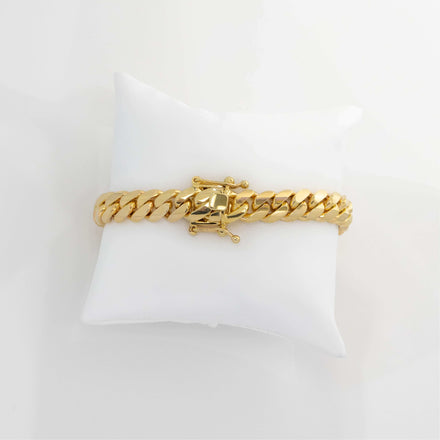 The 8mm Handmade Miami Cuban Link Bracelet in 10K, 14K, or 18K solid gold features a box clasp and is displayed on a white cushion with a plain white background.