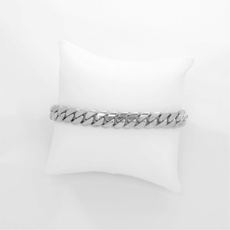 An 8mm Handmade Miami Cuban Link Bracelet in solid 10K, 14K, or 18K gold is displayed on a white cushioned pillow against a plain white background.