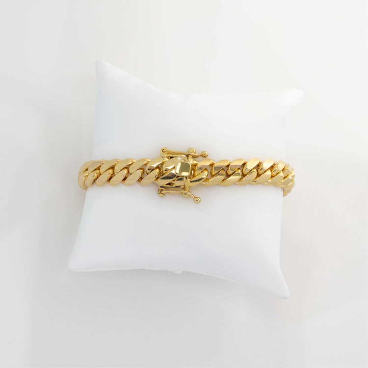The 8mm Handmade Miami Cuban Link Bracelet in 10K, 14K, or 18K solid gold features a box clasp and is displayed on a white cushion with a plain white background.