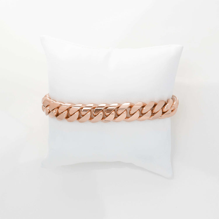 The 11mm Handmade Miami Cuban Link Bracelet in solid 10K, 14K, or 18K gold is displayed on a white cushion against a plain white background.