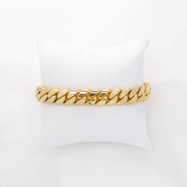 The 12mm Handmade Miami Cuban Link Bracelet in 10K/14K/18K solid gold is displayed on a white cushion and photographed against a plain white background.